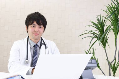 Doktor dizüstü bilgisayarda çalışıyor.