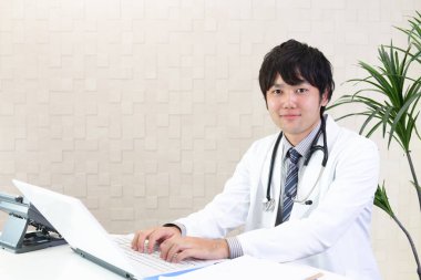 Doktor dizüstü bilgisayarda çalışıyor.