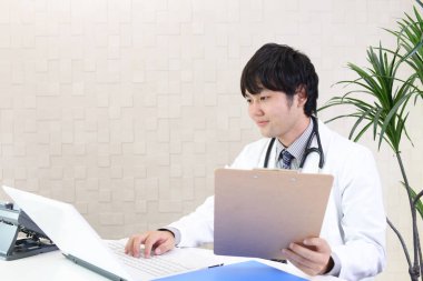 Doktor dizüstü bilgisayarda çalışıyor.