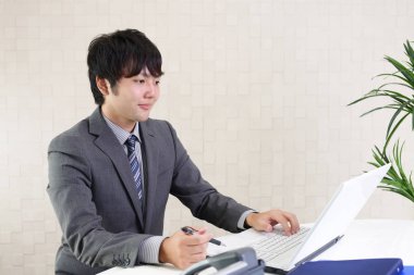 bir dizüstü bilgisayar kullanarak gülümseyen iş adamı