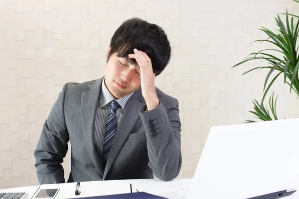 Disappointed Asian businessman at his office