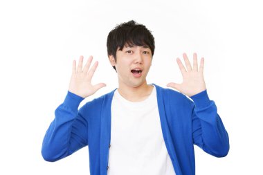 Şaşırmış Asyalı adam beyaz arka planda izole edilmiş.