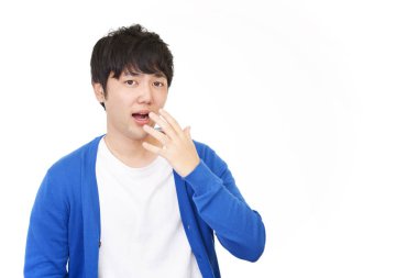 Şaşırmış Asyalı adam beyaz arka planda izole edilmiş.