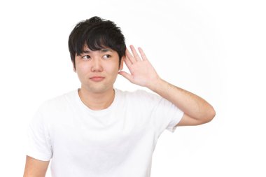 Bir adam elini kulağına koyar.