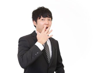 Şaşırmış Asyalı işadamı beyaz arka planda izole edilmiş.