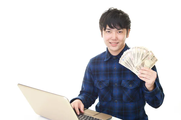 Hombre Usando Ordenador Portátil Mostrando Dinero —  Fotos de Stock