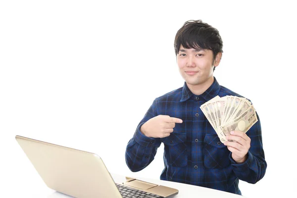 Hombre Usando Ordenador Portátil Mostrando Dinero —  Fotos de Stock