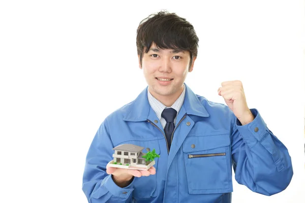 Smiling Asian Worker Housing Model — Stock Photo, Image