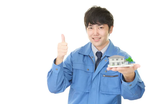 Smiling Asian Worker Housing Model — Stock Photo, Image