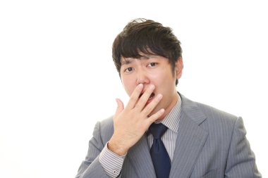 Şaşırmış Asyalı işadamı beyaz arka planda izole edilmiş.