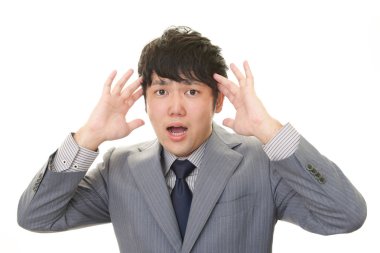 Şaşırmış Asyalı işadamı beyaz arka planda izole edilmiş.