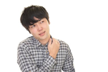 Asyalı bir adam omuz ağrısı çekiyor. 