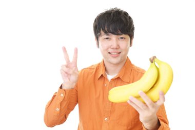 Meyve ile gülümseyen Asyalı adam