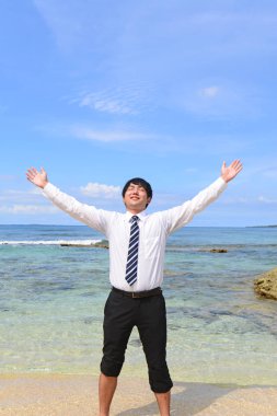 Tropik bir plajda mutlu genç bir adamın portresi.