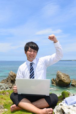 Tropik bir plajda mutlu genç bir adamın portresi.