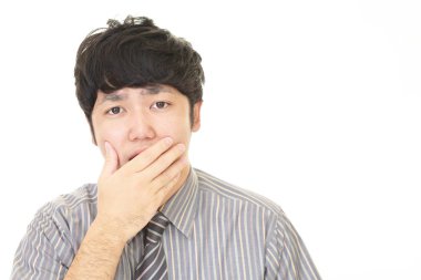 Şaşırmış Asyalı işadamı beyaz arka planda izole edilmiş.