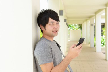 Asya adam akıllı telefon tutarak