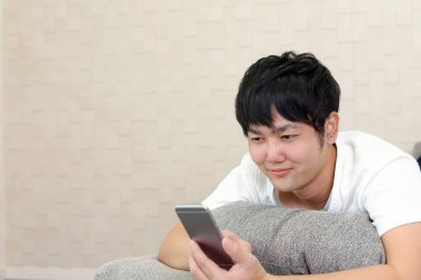 Bir akıllı telefon kullanan Asyalı adam