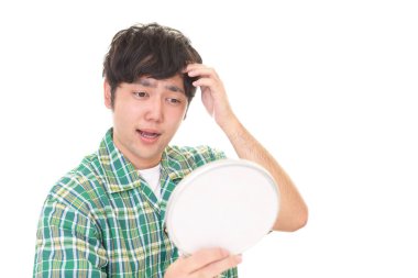 Asyalı erkek saçı aynaya bakıyor