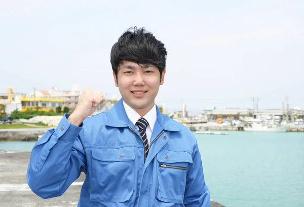 Asya adam işçi giyiyor mavi üniforma gülümseyen