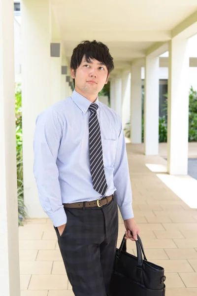 Relaxed Asian businessman with a bag