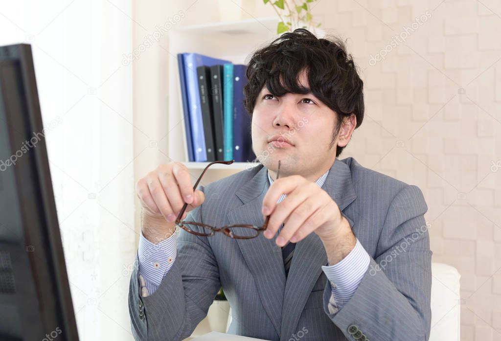 Asian businessman with eyestrain