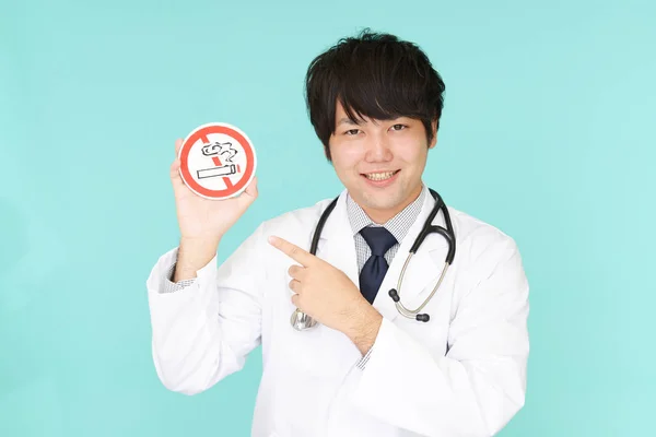 Doctor holds non smoking sign