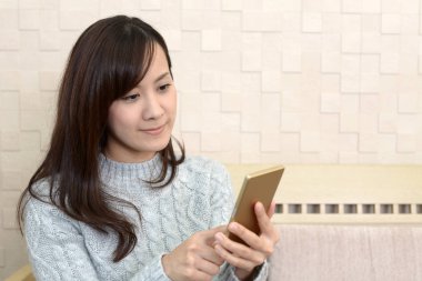 Bir akıllı telefon kullanan gülümseyen kadın