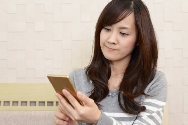 Bir akıllı telefon kullanan gülümseyen kadın