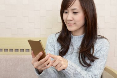 Bir akıllı telefon kullanan gülümseyen kadın