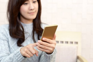 Bir akıllı telefon kullanan gülümseyen kadın