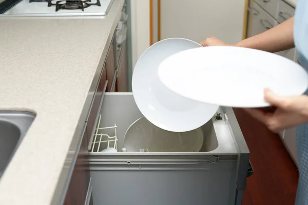 食器洗い機の食器を出して女性 — ストック写真