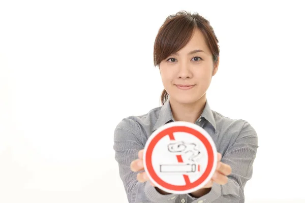 Woman holds non smoking sign