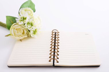 Masanın üzerine çiçek telli defter kitapla