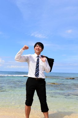 Tropikal bir plajda mutlu bir adam portresi