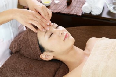 güzel bir genç kadın kapalı gözlerle yüz masajı bir spa salonda alma 