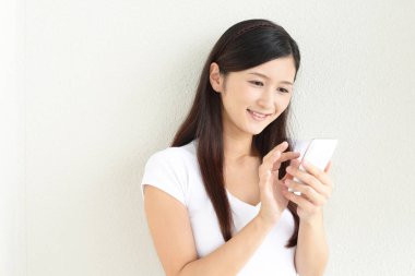 Bir akıllı telefon kullanan gülümseyen kadın