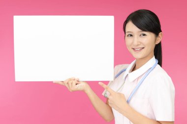 Bir beyaz tahta ile gülümseyen kadın hemşire