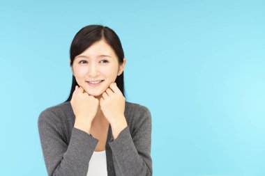 Gülümseyen genç kadın üzerinde mavi arka plan izole