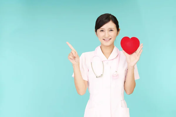 Usmívající Asijské Zdravotní Sestra Drží Symbol Lásky Červené Srdce — Stock fotografie