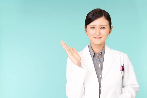 Smiling Asian Pharmacist Shows Way — Stock Photo, Image