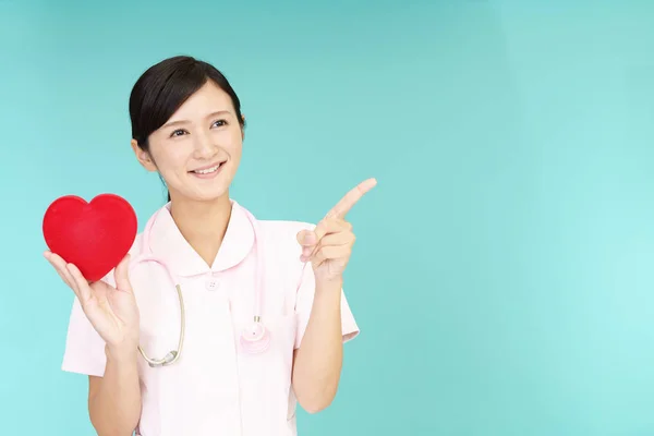 Улыбающаяся Азиатская Медсестра Красным Сердцем — стоковое фото
