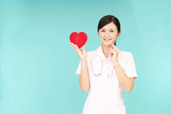 赤いハートと笑顔のアジアの看護師 — ストック写真