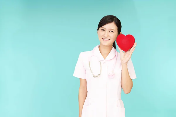 Uśmiechający Się Pielęgniarka Czerwonym Sercem — Zdjęcie stockowe