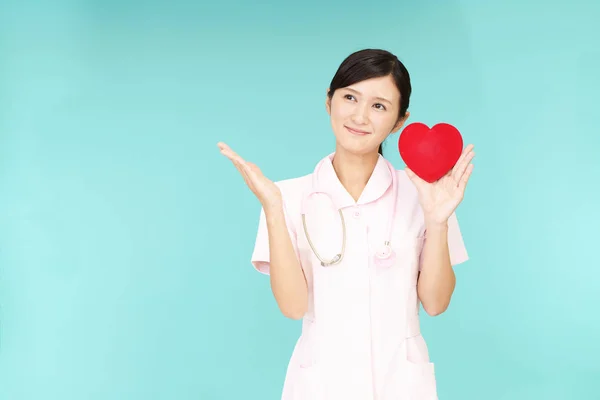 Uśmiechający Się Pielęgniarka Czerwonym Sercem — Zdjęcie stockowe
