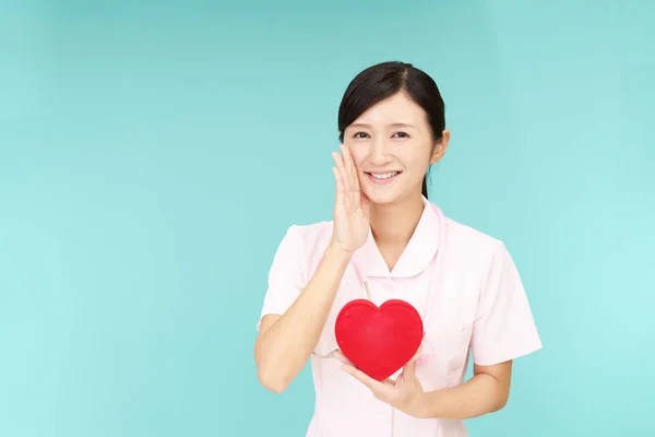 Sonriente Asiática Enfermera Sosteniendo Rojo Corazón Amor Símbolo — Foto de Stock