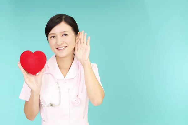 Asyalı Hemşire Kırmızı Kalp Aşk Sembolü Tutan Gülümseyerek — Stok fotoğraf