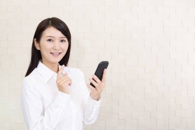 Bir akıllı telefon kullanan gülümseyen kadın