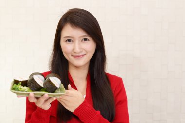 Rulo suşi ile gülümseyen kadın