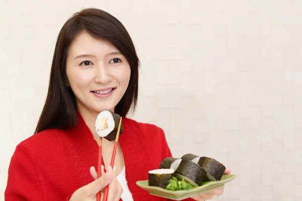 Woman eating sushi rolls